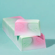 Blumenmaedchen PFLANZLICHE SEIFE Kirschblüte, Ein Seifenblock und ein frisch abgeschnittenes Seifenstück mit leuchtenden Farben. Pink, Grün, Weiss